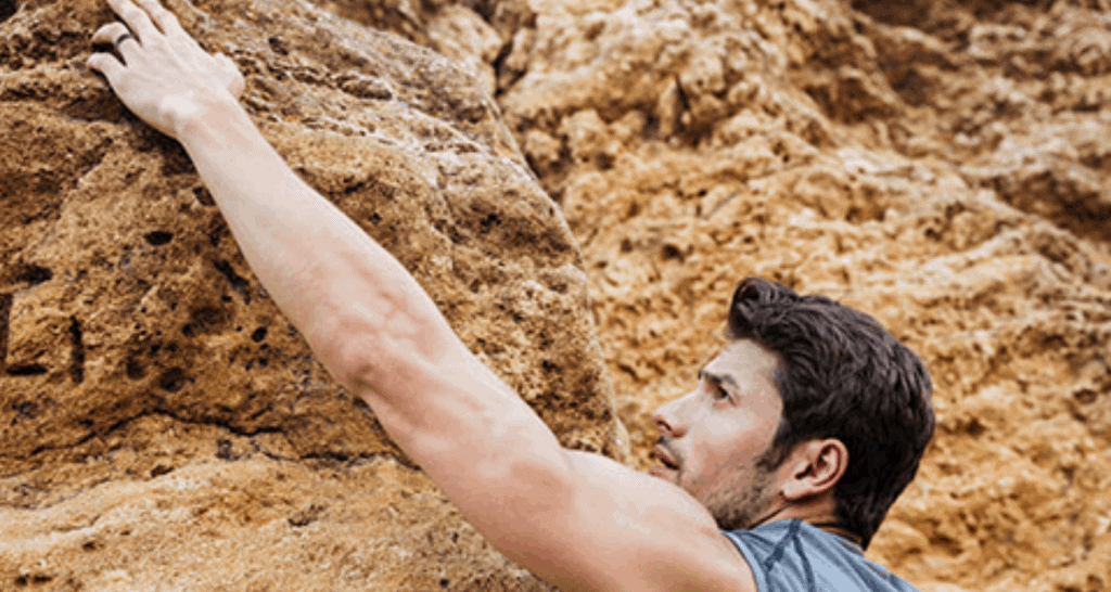Inspirational man rock climbing showing his inspiring ring design