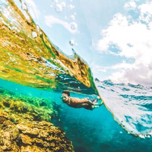 Mann schwimmt mit seinem Wolframring im Meer