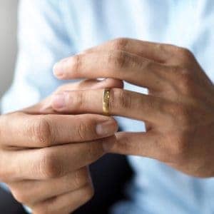 Mann probiert seinen Ehering an