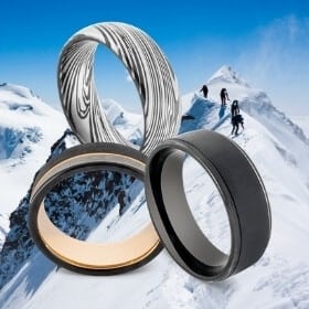 3 schwarze Ringe für Männer vor schneebedeckten Bergen im Hintergrund