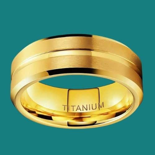Goldener Titanring für Männer auf blaugrünem Hintergrund