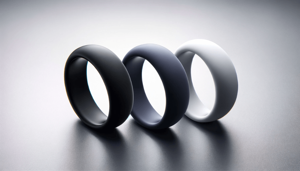 A different angle of three solid-colored silicone rings on a sophisticated backdrop.